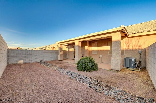 exterior space featuring stucco siding, a patio area, a fenced backyard, and central AC unit