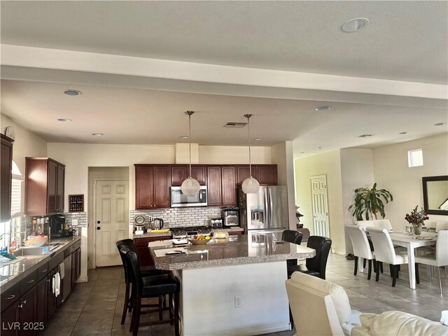 5320 Tartan Hill Ave, Las Vegas, NV 89141 - kitchen featuring a center island, decorative light fixtures, decorative backsplash, appliances with stainless steel finishes, and a kitchen bar