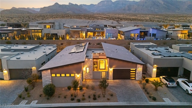 view of front of home featuring stone siding, a residential view, a mountain view, and decorative driveway