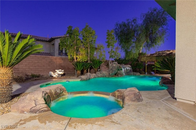 view of swimming pool featuring a fenced backyard and a pool with connected hot tub