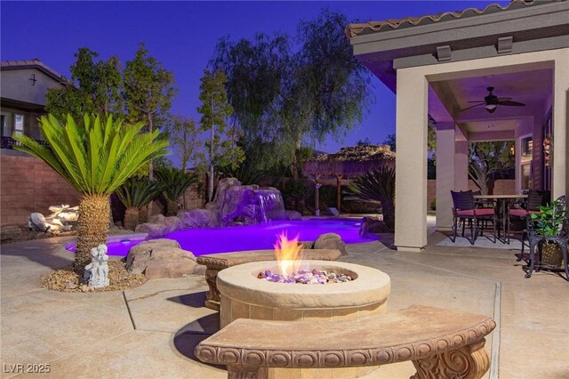 view of patio / terrace featuring an outdoor fire pit, fence, and ceiling fan