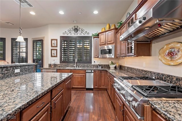 kitchen featuring dark wood-style flooring, stainless steel appliances, a sink, dark stone countertops, and exhaust hood