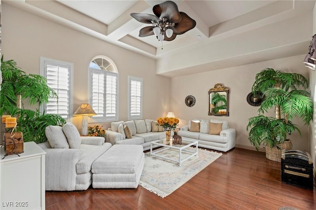 living area featuring coffered ceiling, a ceiling fan, baseboards, beam ceiling, and dark wood finished floors