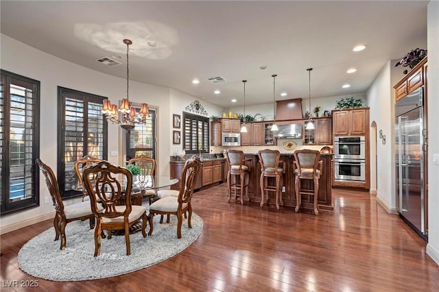 dining space with recessed lighting, visible vents, dark wood finished floors, and an inviting chandelier