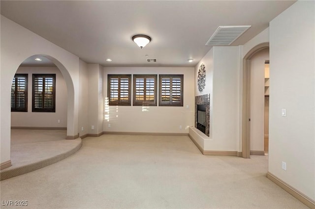 unfurnished living room with recessed lighting, carpet flooring, visible vents, baseboards, and a tiled fireplace