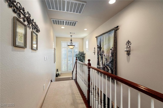 corridor featuring recessed lighting, visible vents, baseboards, and an upstairs landing