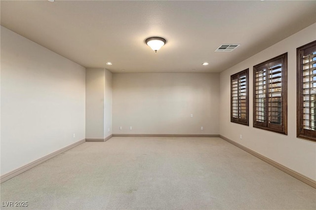 unfurnished room with recessed lighting, light colored carpet, visible vents, and baseboards