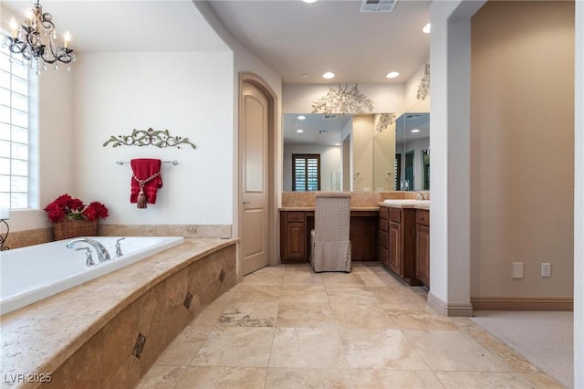 bathroom featuring visible vents, plenty of natural light, a garden tub, and vanity