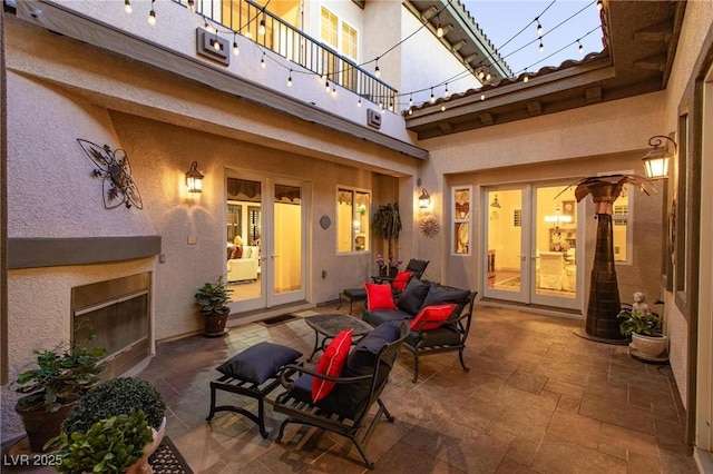 view of patio / terrace with a glass covered fireplace and french doors