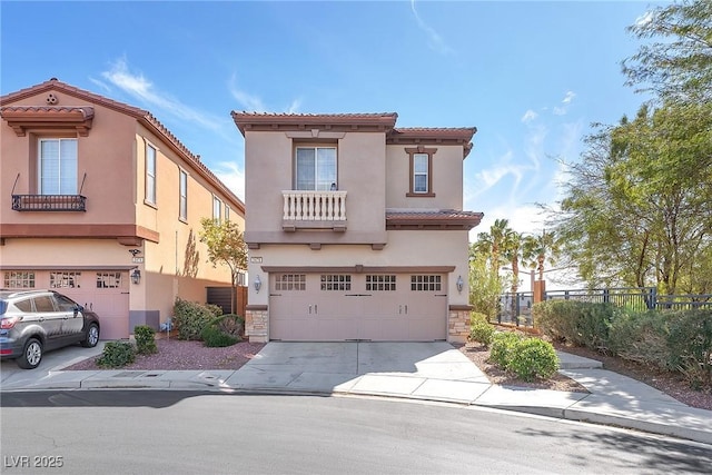 mediterranean / spanish house featuring stucco siding, driveway, fence, an attached garage, and a tiled roof