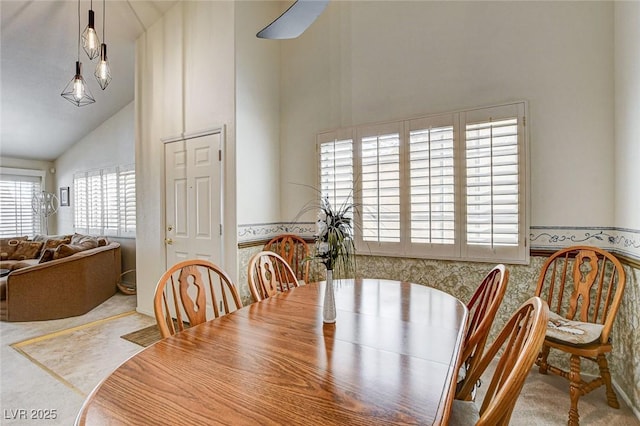 dining space with high vaulted ceiling