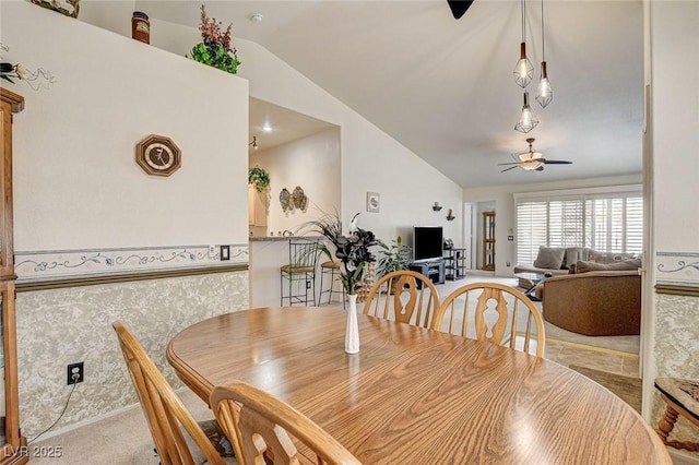 dining area featuring lofted ceiling, wallpapered walls, ceiling fan, and carpet