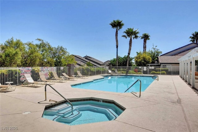 community pool with a patio area, a hot tub, and fence