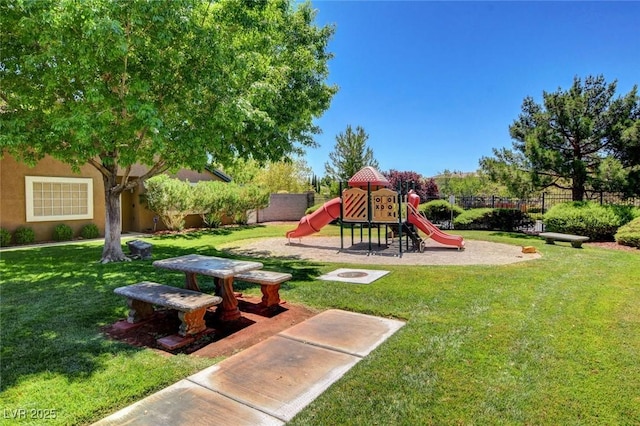 community jungle gym with a lawn and fence