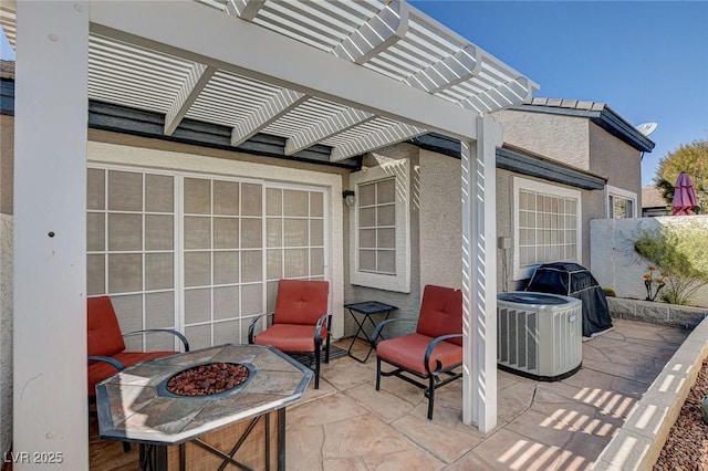 view of patio / terrace with a fire pit, central AC unit, and a pergola