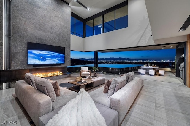 living room featuring a large fireplace and a high ceiling