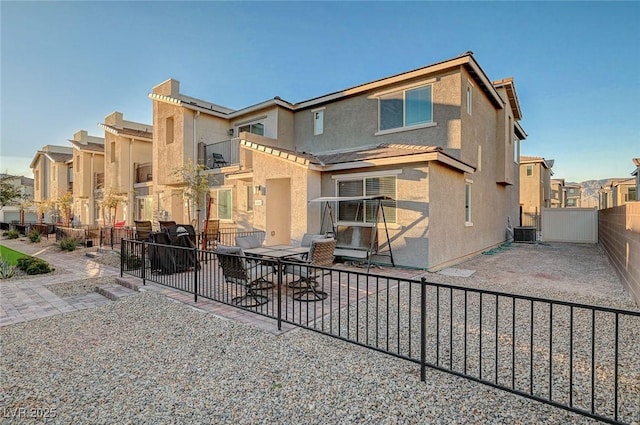 back of house featuring a residential view, a fenced backyard, a patio, and stucco siding