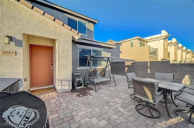 view of patio with outdoor dining area and fence