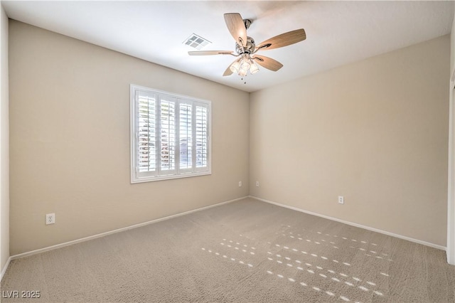 carpeted spare room with a ceiling fan, visible vents, and baseboards