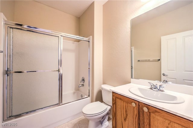 bathroom with shower / bath combination with glass door, vanity, toilet, and tile patterned floors