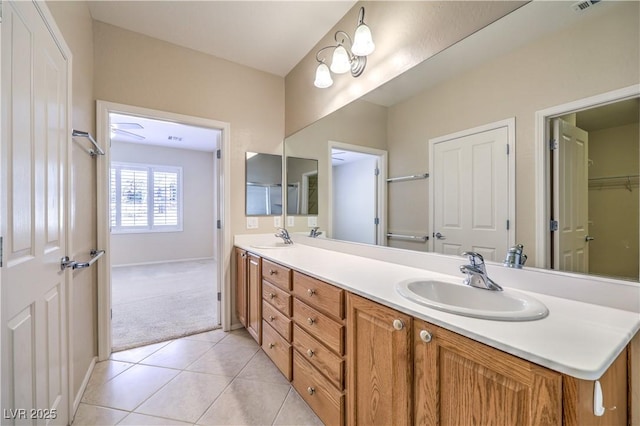 bathroom featuring tile patterned floors, a sink, baseboards, and double vanity