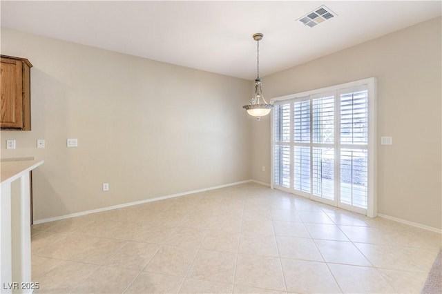 unfurnished dining area featuring light tile patterned flooring, visible vents, and baseboards