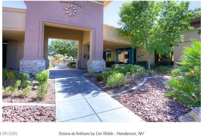 entrance to property featuring stone siding and stucco siding