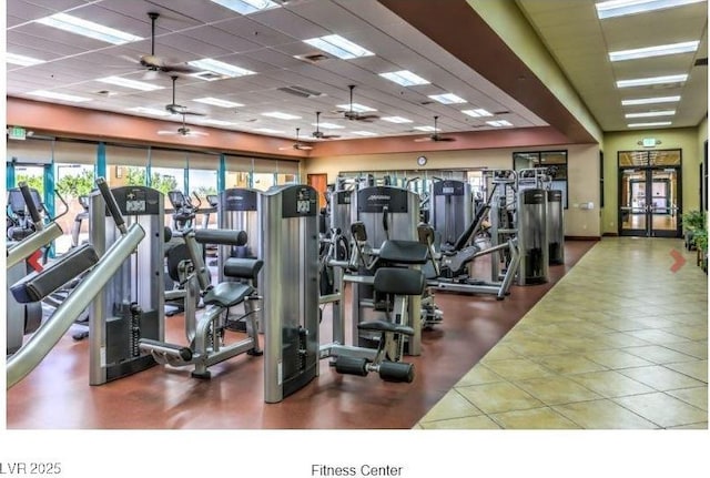 exercise room with tile patterned flooring, a drop ceiling, and ceiling fan