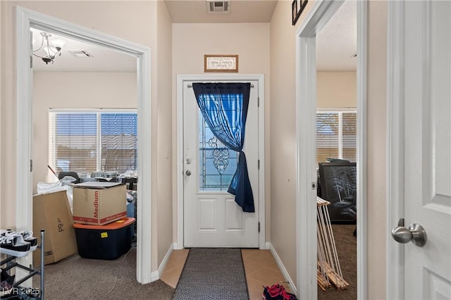 entryway with light tile patterned flooring, visible vents, and baseboards