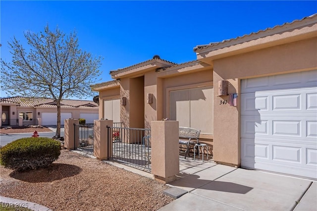 property entrance featuring a tile roof, fence, an attached garage, and stucco siding