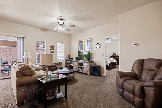 living room with a textured ceiling, carpet, and a ceiling fan