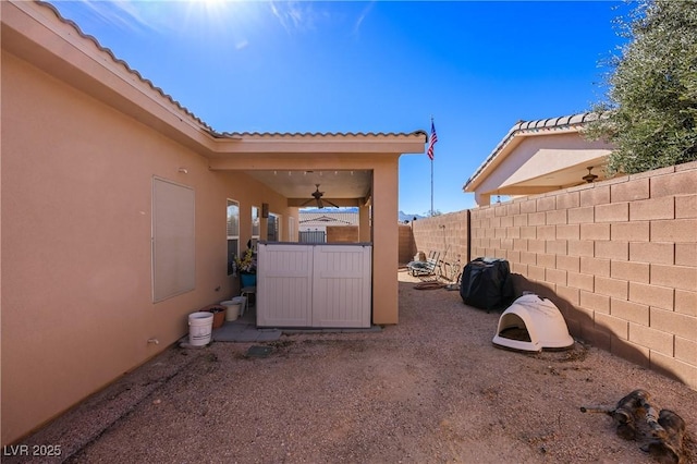 view of yard featuring ceiling fan and fence