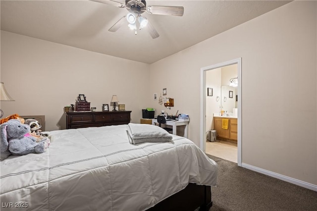 carpeted bedroom featuring ensuite bathroom, a ceiling fan, and baseboards