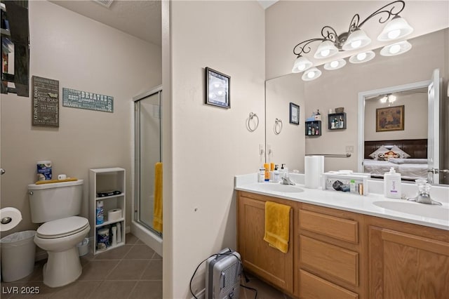 ensuite bathroom with double vanity, connected bathroom, tile patterned floors, a shower stall, and a sink