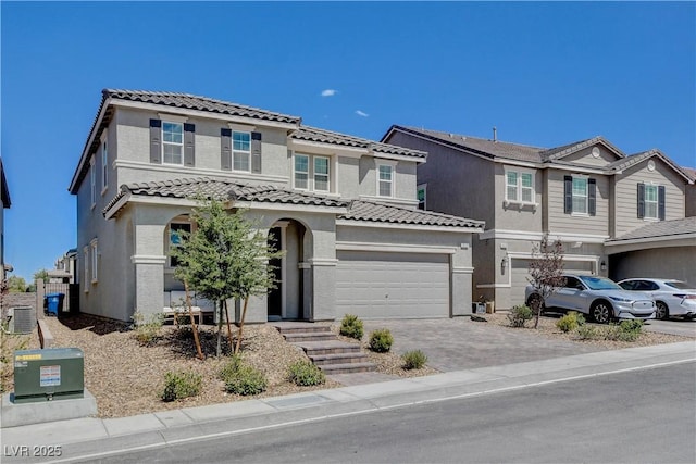 view of front of house featuring driveway, a garage, a tiled roof, cooling unit, and stucco siding