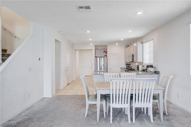 dining room featuring recessed lighting, visible vents, light tile patterned flooring, light carpet, and stairs