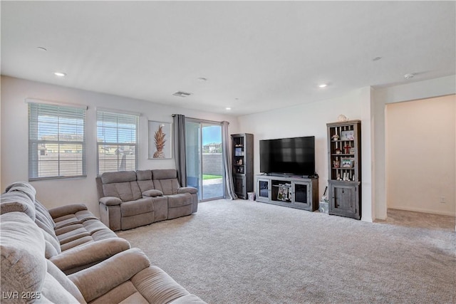 living room with recessed lighting, light colored carpet, and visible vents