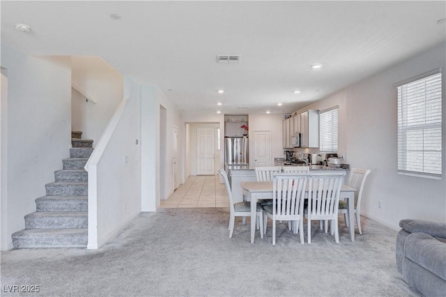 dining room featuring light tile patterned floors, visible vents, light colored carpet, stairway, and recessed lighting