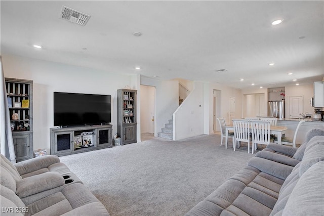 living room with light carpet, stairway, visible vents, and recessed lighting