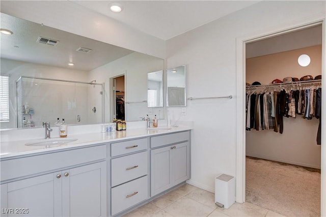 full bathroom featuring a spacious closet, a sink, and visible vents