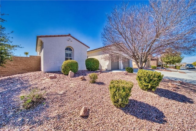 mediterranean / spanish-style home with an attached garage, driveway, a tile roof, and stucco siding