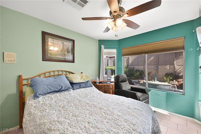 bedroom with ceiling fan, visible vents, baseboards, and light tile patterned flooring