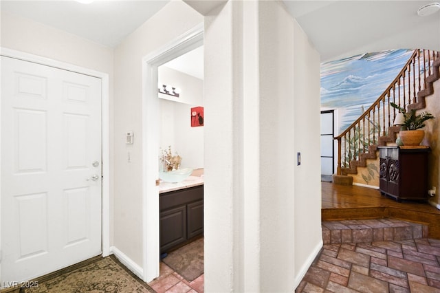 interior space with stone finish flooring, baseboards, and stairs