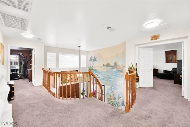 hall featuring a wealth of natural light, light colored carpet, visible vents, and an upstairs landing