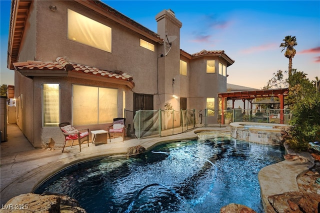 back of property featuring a tile roof, a patio area, fence, and stucco siding