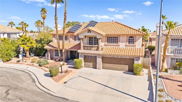 mediterranean / spanish-style house with stucco siding, stone siding, a tile roof, and solar panels