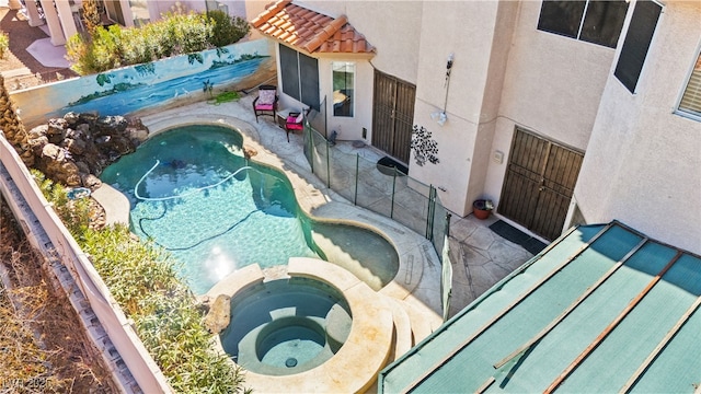 view of swimming pool featuring an in ground hot tub and a fenced in pool