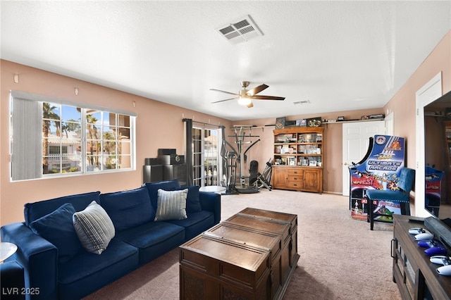 carpeted living room with a ceiling fan, visible vents, and a textured ceiling