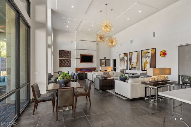 interior space with a towering ceiling, visible vents, a notable chandelier, and recessed lighting