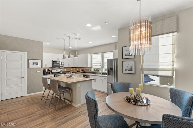 dining room with light wood-type flooring, visible vents, a chandelier, and recessed lighting